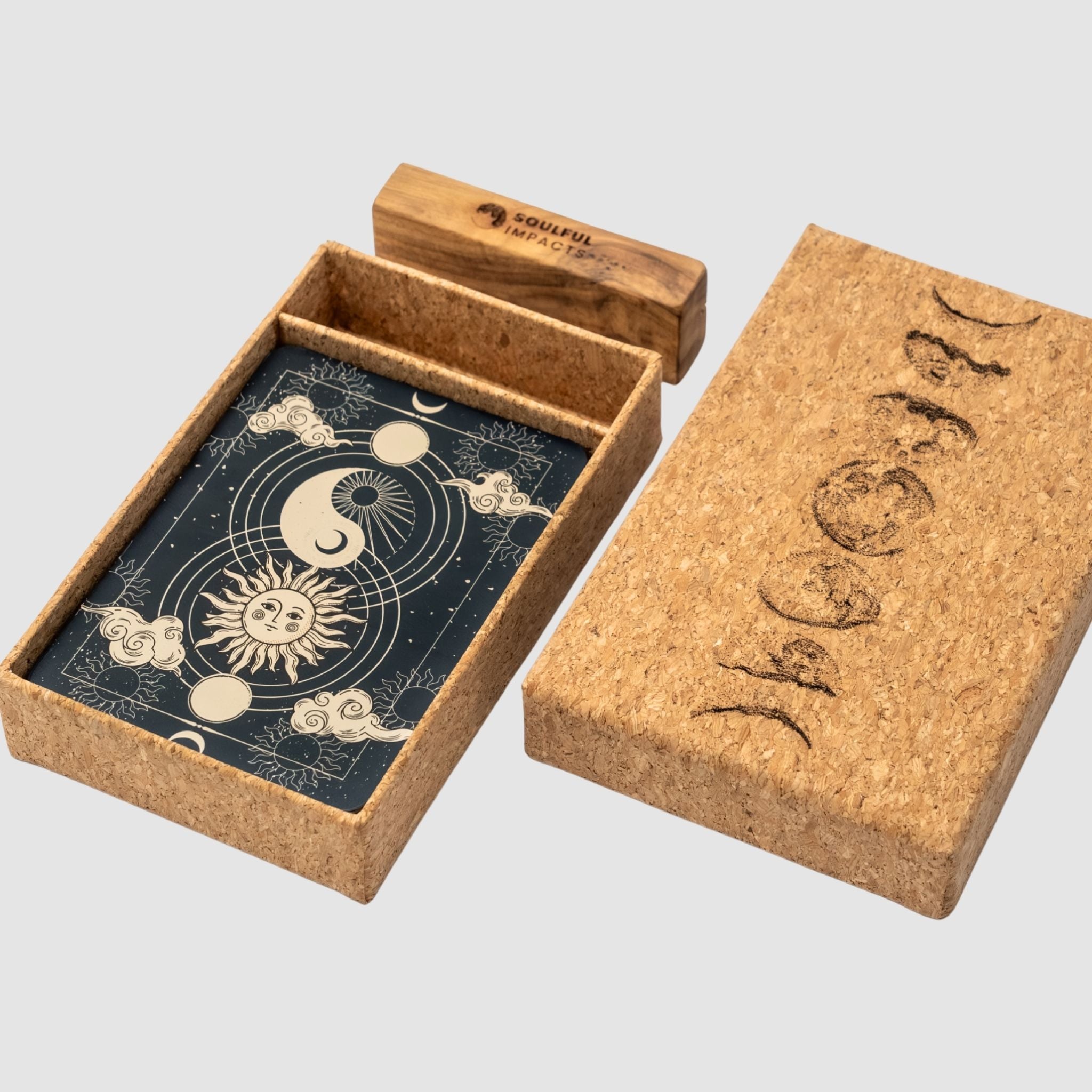 Open cork card box with moon phase design, cards inside, wood card stand holder, on a light gray background