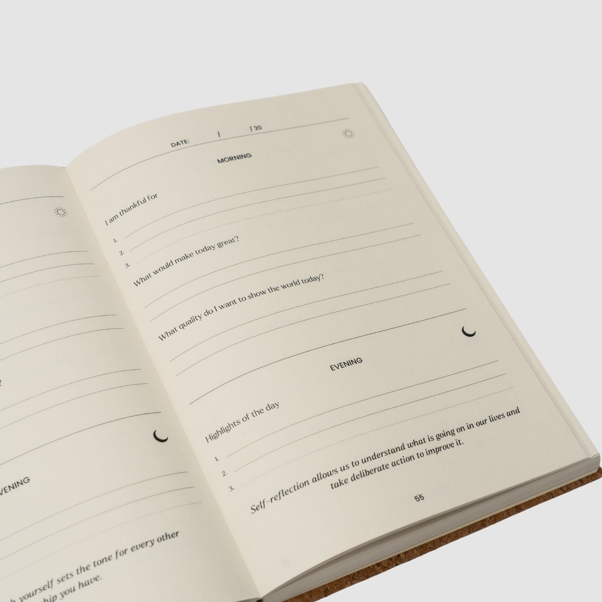 Open notebook with daily reflection prompts on a white background