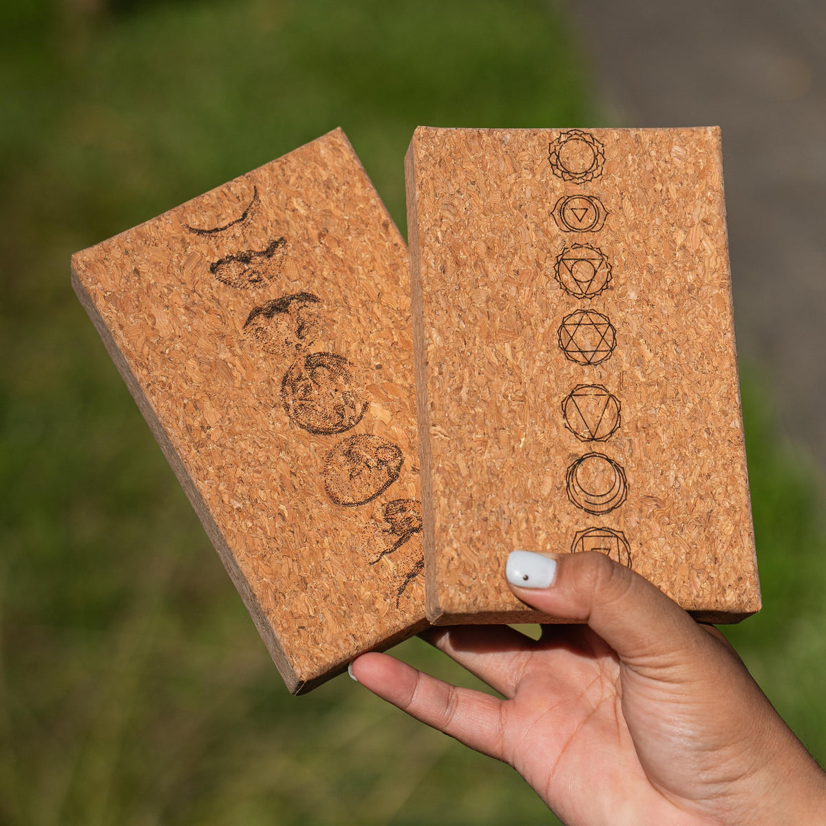 Hand holding the Moon Mantra and Chakra oracle deck cork boxes outdoors