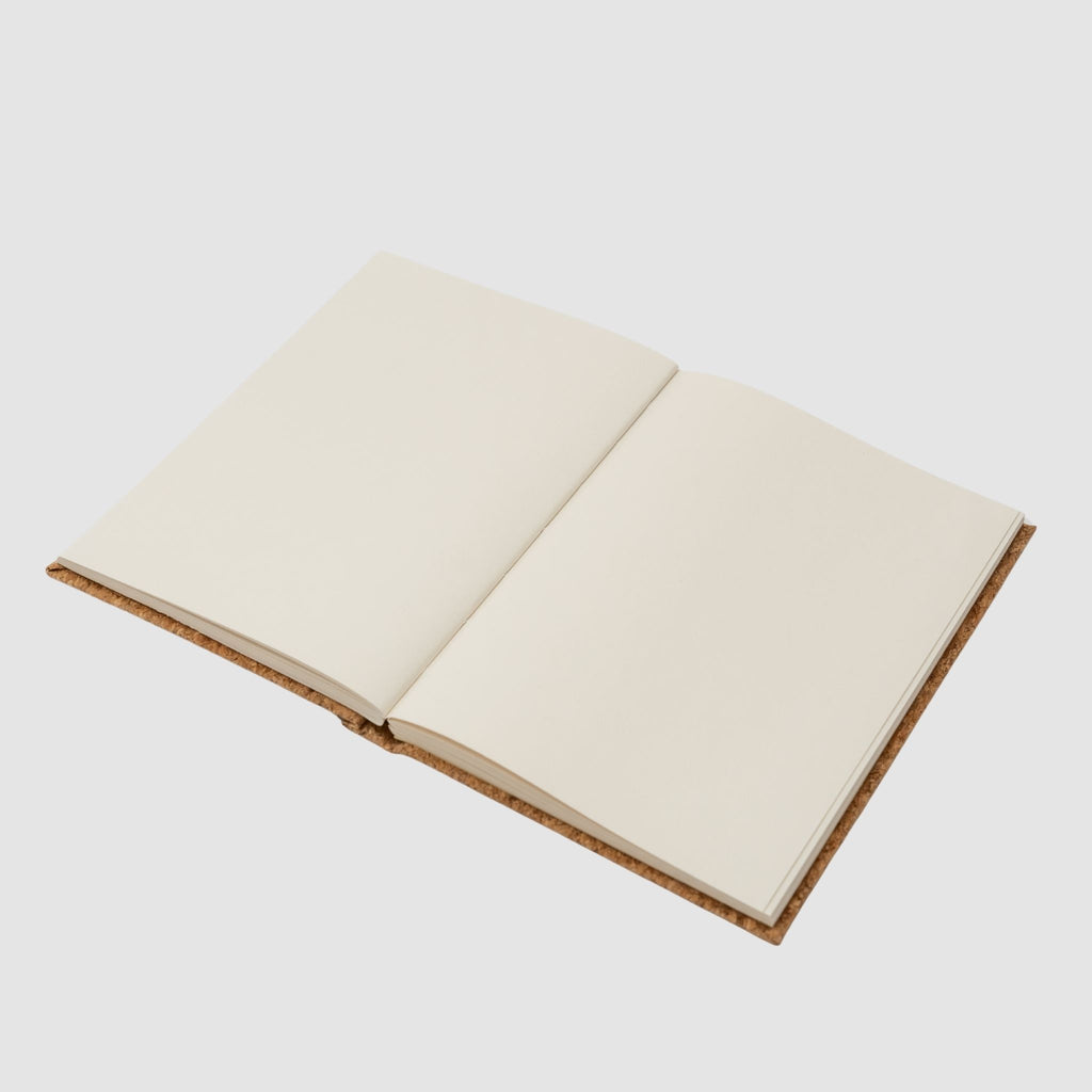 Open hardcover notebook with cream-colored pages, sitting on a white background