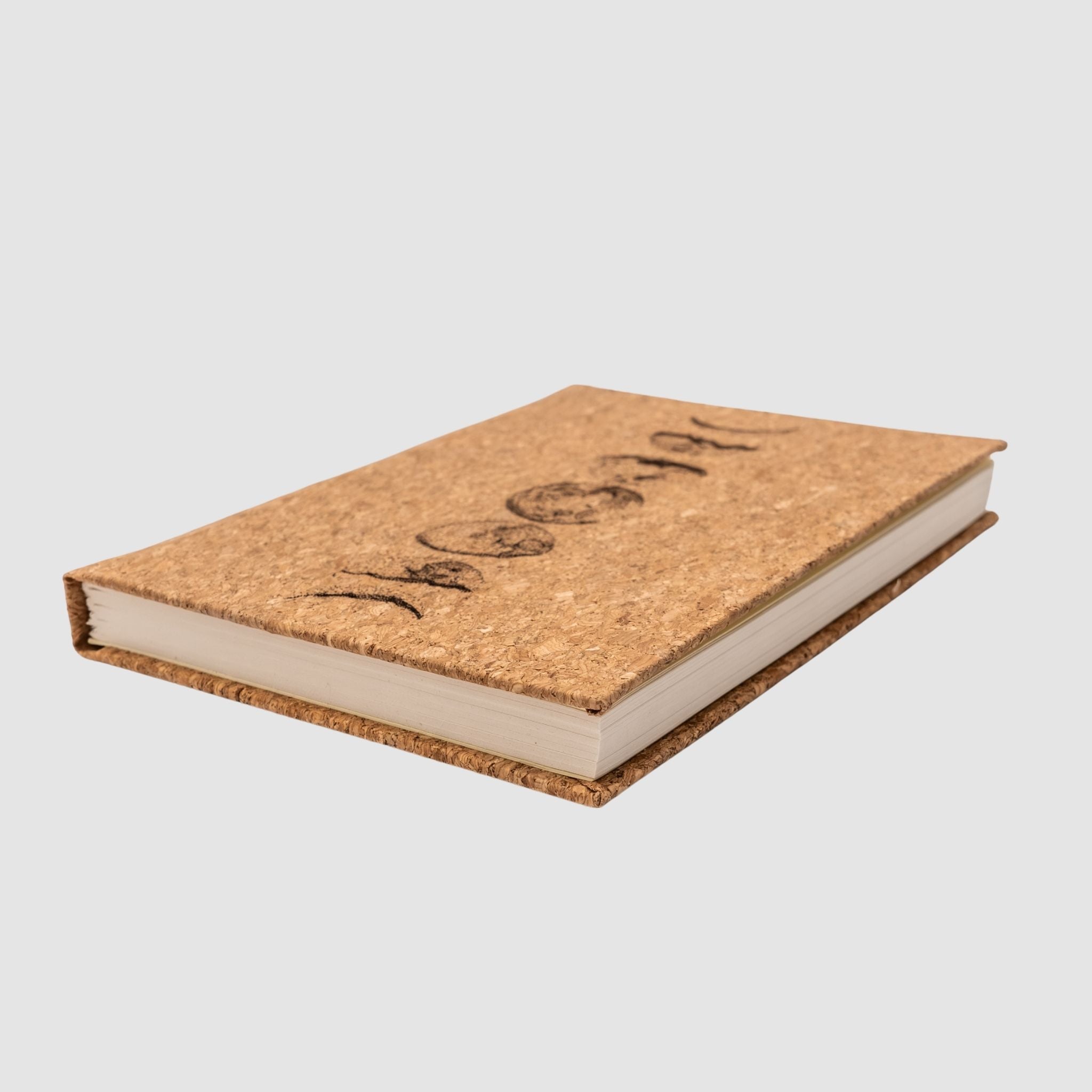 Cork hardcover blank notebook with moon cycle design, sitting tilted, on a white background