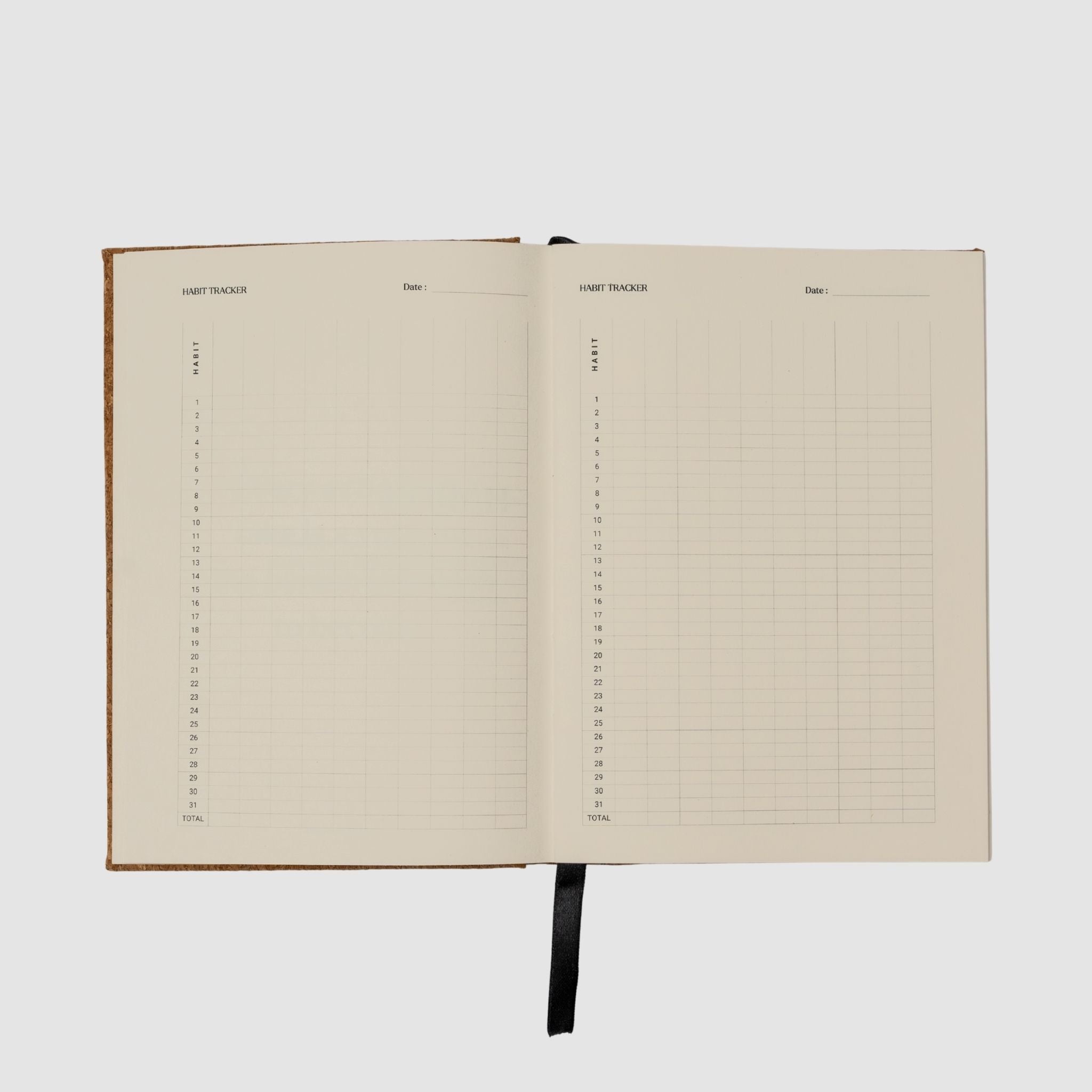 Open notebook with habit tracker grid pages on a white background